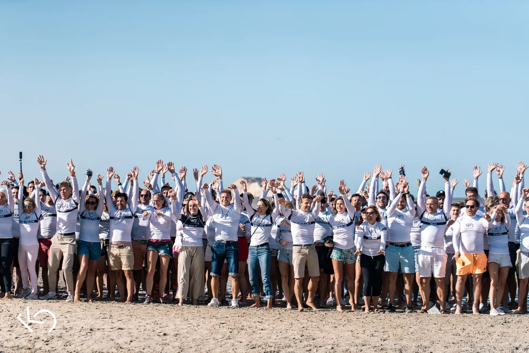 Les participants du B2B Kite Summit, les bras en l'air sur la plage